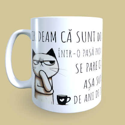 Cană ceramică personalizată „Credeam că sunt doar într-o pasă proastă dar se pare că așa sunt de ani de zile” – 330 ml, albă